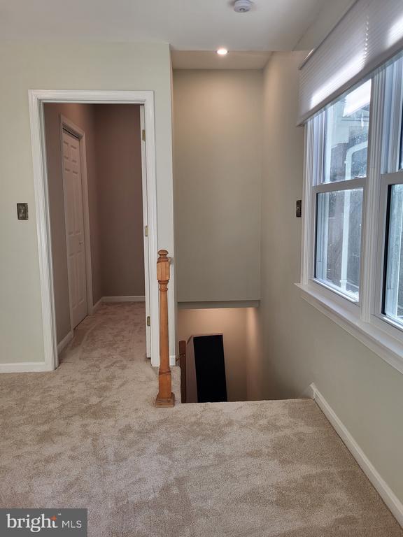  - hall featuring an upstairs landing, carpet, and baseboards