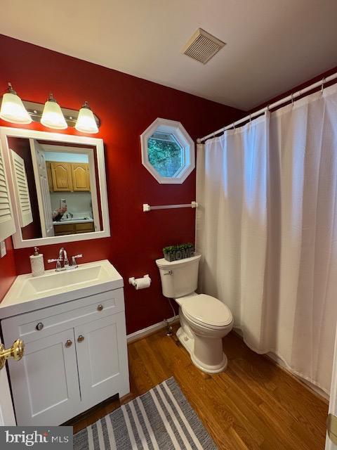  - bathroom featuring wood finished floors, toilet, vanity, and baseboards