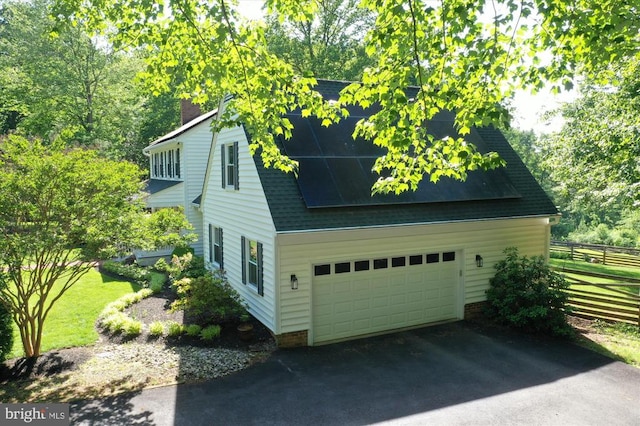  - view of side of home with a chimney and roof with shingles