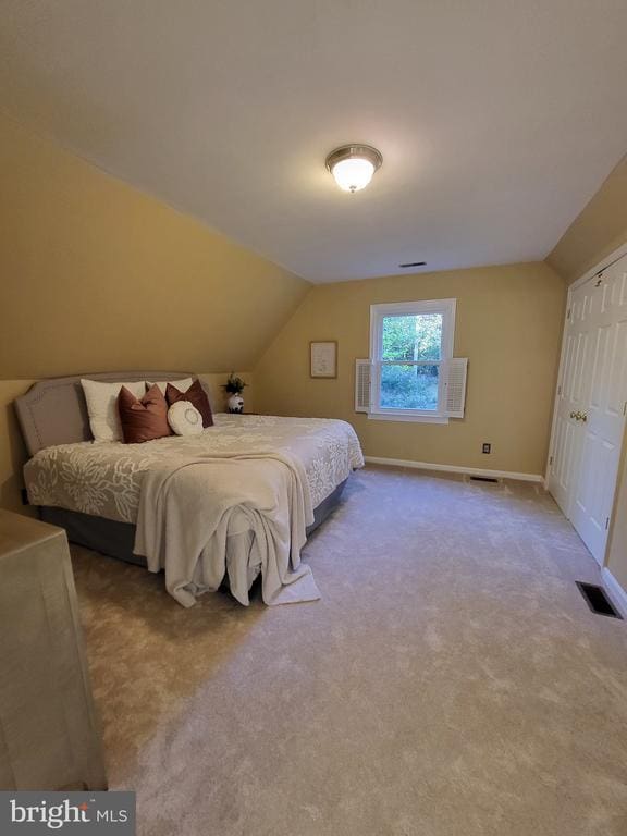  - carpeted bedroom with vaulted ceiling and baseboards