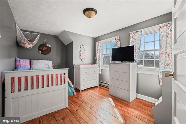 885 Main St W, Stanley, VA 22851 - bedroom with baseboard heating, wood finished floors, and baseboards