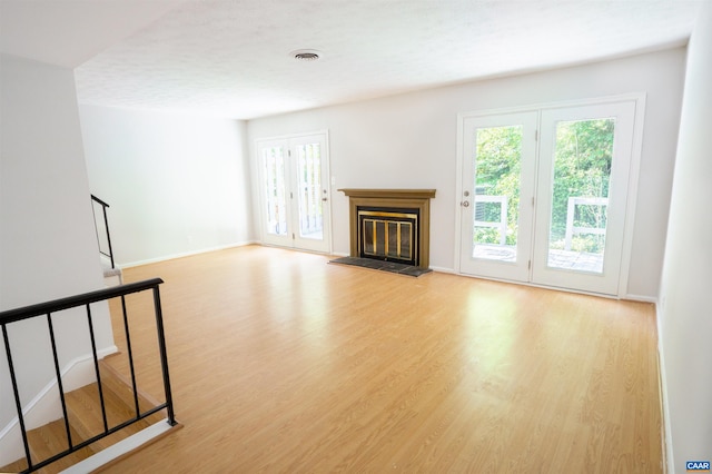158 Scarborough Pl, Charlottesville, VA 22903 - unfurnished living room with wood finished floors, healthy amount of natural light, a glass covered fireplace, and stairs