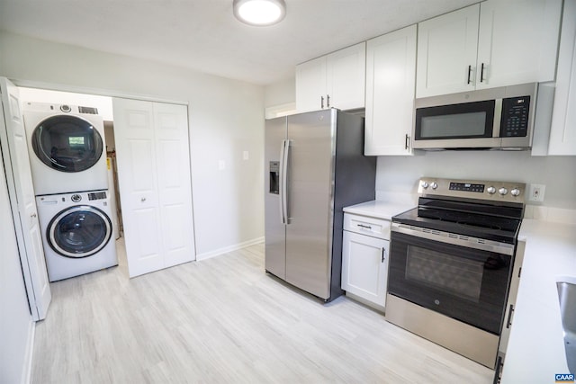 158 Scarborough Pl, Charlottesville, VA 22903 - kitchen with stainless steel appliances, stacked washer and clothes dryer, light countertops, light wood finished floors, and white cabinetry