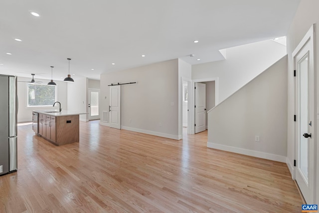 34 Turkeysag Trl, Palmyra, VA 22963 - unfurnished living room featuring a barn door, light wood-style floors, and recessed lighting