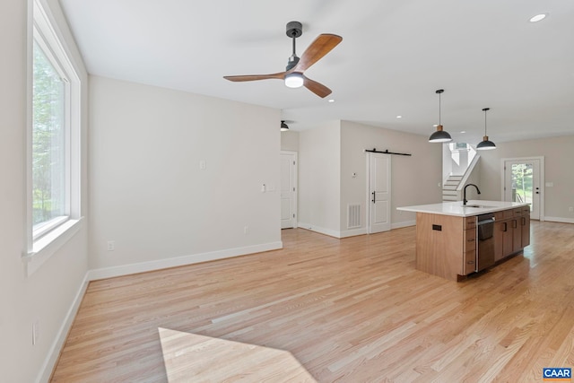 34 Turkeysag Trl, Palmyra, VA 22963 - kitchen featuring a barn door, stainless steel dishwasher, a ceiling fan, light wood-type flooring, and a center island with sink
