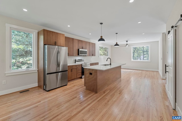 34 Turkeysag Trl, Palmyra, VA 22963 - kitchen featuring stainless steel appliances, a barn door, brown cabinets, light countertops, and recessed lighting