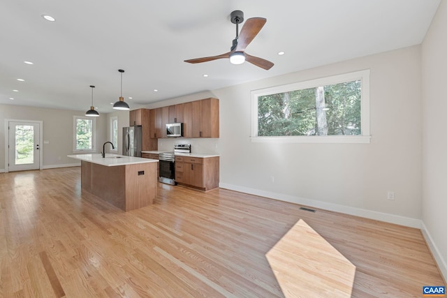 34 Turkeysag Trl, Palmyra, VA 22963 - kitchen with appliances with stainless steel finishes, light countertops, brown cabinets, a center island with sink, and open floor plan