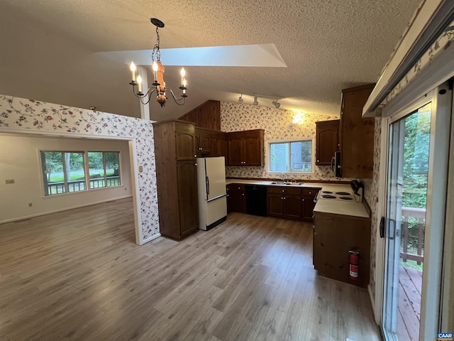 7 Englewood Dr, Palmyra, VA 22963 - kitchen with white appliances, wallpapered walls, a chandelier, vaulted ceiling, and a textured ceiling