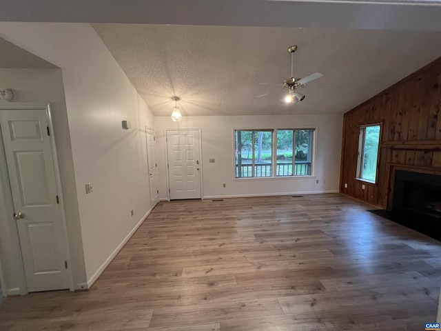 7 Englewood Dr, Palmyra, VA 22963 - unfurnished living room with lofted ceiling, ceiling fan, wood finished floors, a large fireplace, and a textured ceiling