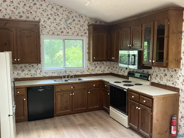 7 Englewood Dr, Palmyra, VA 22963 - kitchen with white appliances, wallpapered walls, light wood-type flooring, light countertops, and glass insert cabinets