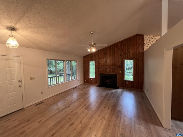 7 Englewood Dr, Palmyra, VA 22963 - unfurnished living room featuring ceiling fan, light wood-style floors, wood walls, high vaulted ceiling, and a large fireplace