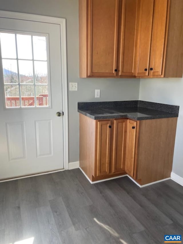 1414 Midland St, Charlottesville, VA 22902 - kitchen featuring dark wood-type flooring, baseboards, brown cabinets, and dark stone countertops