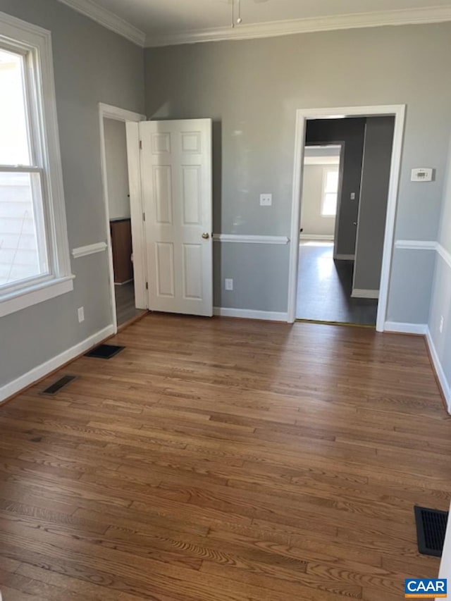 1414 Midland St, Charlottesville, VA 22902 - unfurnished bedroom featuring crown molding, multiple windows, baseboards, and wood finished floors
