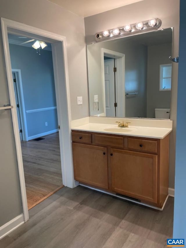 1414 Midland St, Charlottesville, VA 22902 - half bathroom with wood finished floors, vanity, a ceiling fan, and baseboards
