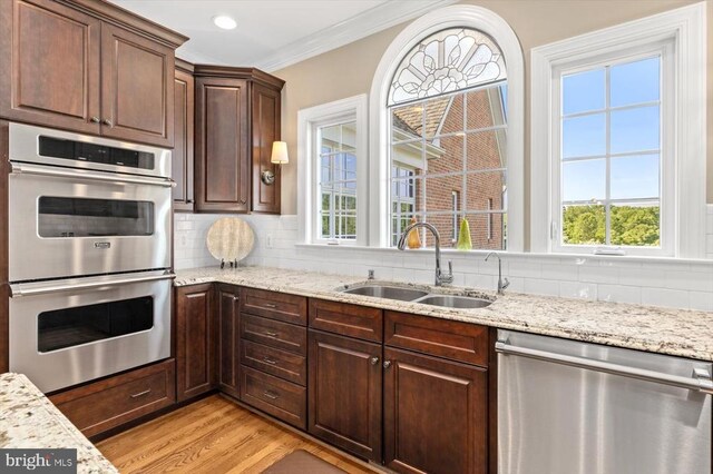 10042 Cedar Spring Ln, Culpeper, VA 22701 - kitchen with appliances with stainless steel finishes, tasteful backsplash, light wood-style floors, light stone counters, and ornamental molding