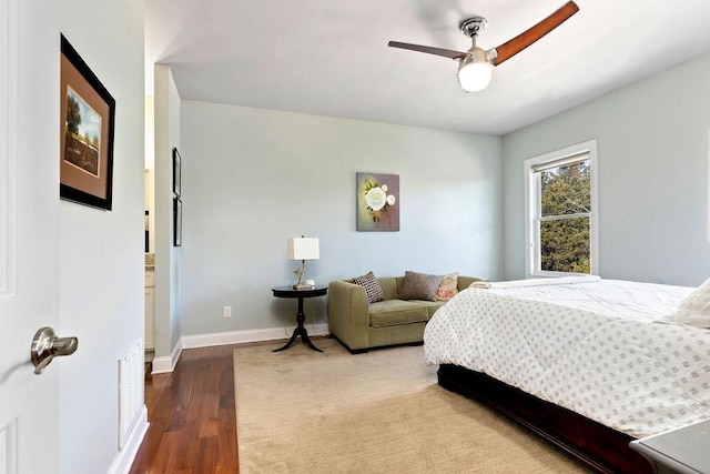 bedroom featuring a ceiling fan, baseboards, and wood finished floors