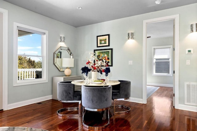 dining area featuring wood finished floors, visible vents, and baseboards