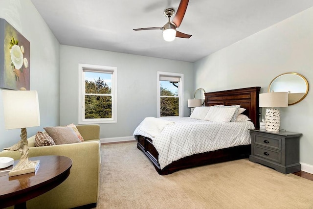 bedroom featuring a ceiling fan, baseboards, and light carpet