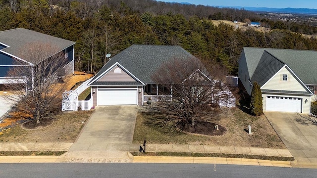 view of front of house featuring a gate, driveway, a forest view, and fence