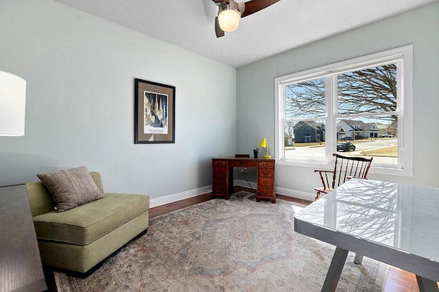 sitting room with baseboards, wood finished floors, and a ceiling fan