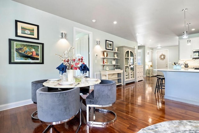 dining room with dark wood-type flooring, recessed lighting, and baseboards