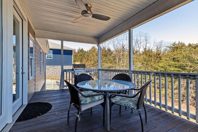 wooden deck with grilling area, outdoor dining area, and a ceiling fan