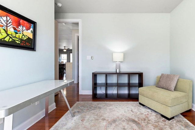 living area with baseboards and wood finished floors