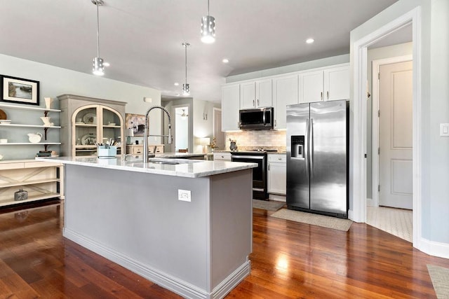 kitchen featuring a sink, decorative backsplash, dark wood-type flooring, appliances with stainless steel finishes, and decorative light fixtures