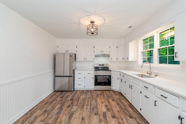 9048 Cinder Run Ln, Elkton, VA 22827 - kitchen featuring appliances with stainless steel finishes, white cabinetry, dark wood-style floors, under cabinet range hood, and a wainscoted wall