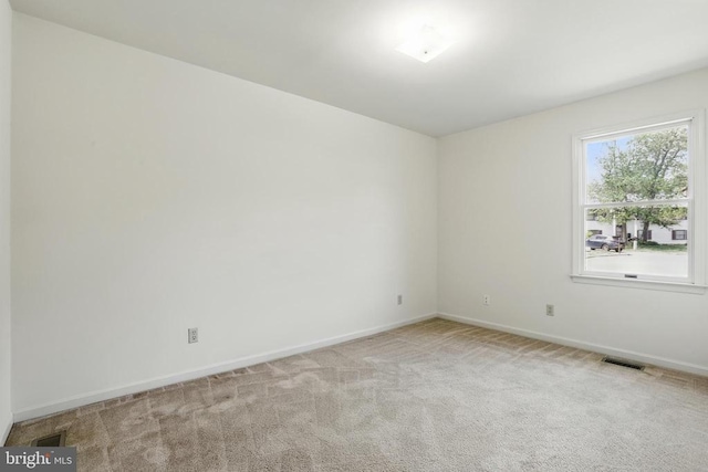 empty room with baseboards and carpet