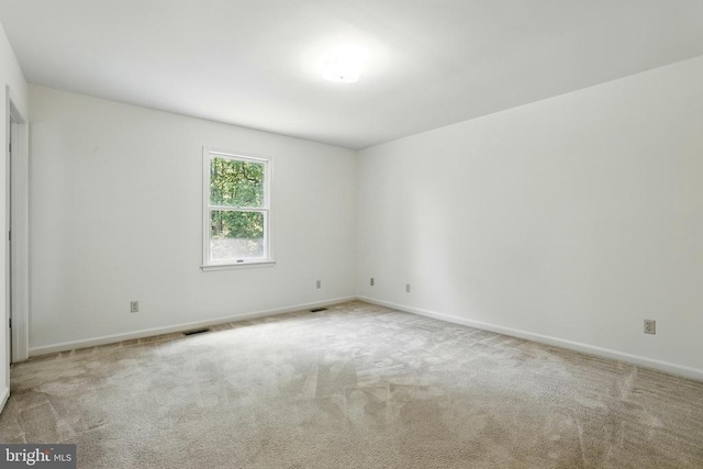 carpeted spare room with baseboards