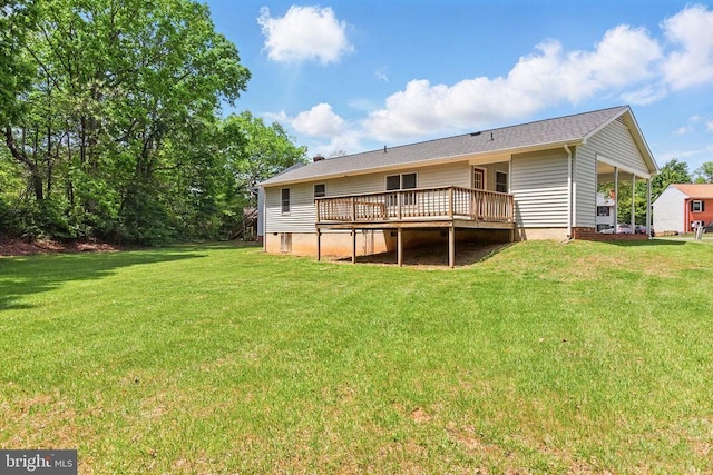 rear view of house with a wooden deck, a lawn, and a carport