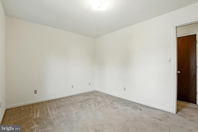 carpeted spare room featuring baseboards