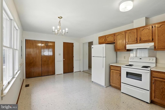 kitchen with white appliances, under cabinet range hood, a chandelier, brown cabinetry, and light countertops