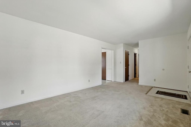 carpeted empty room featuring baseboards