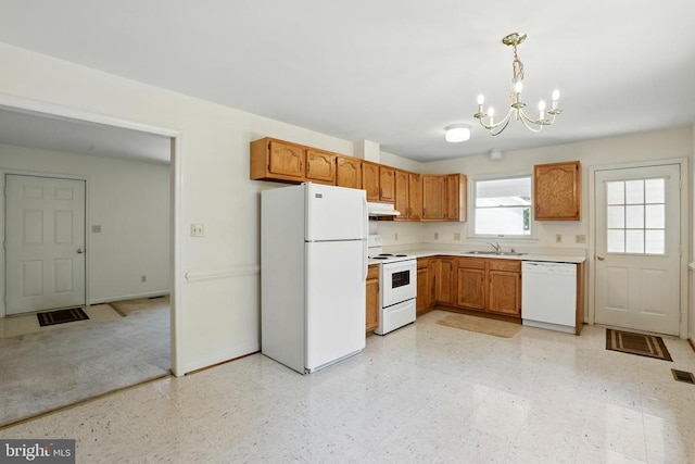 kitchen featuring white appliances, a chandelier, a sink, light countertops, and baseboards