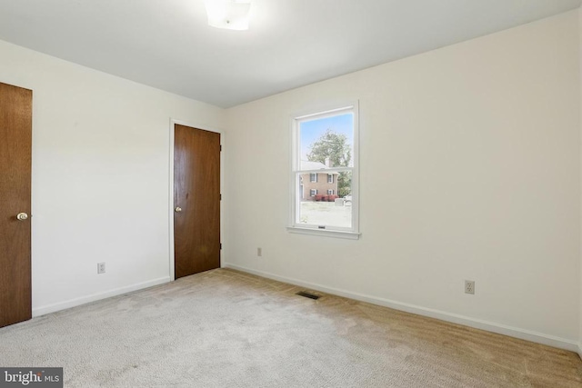 empty room featuring carpet and baseboards