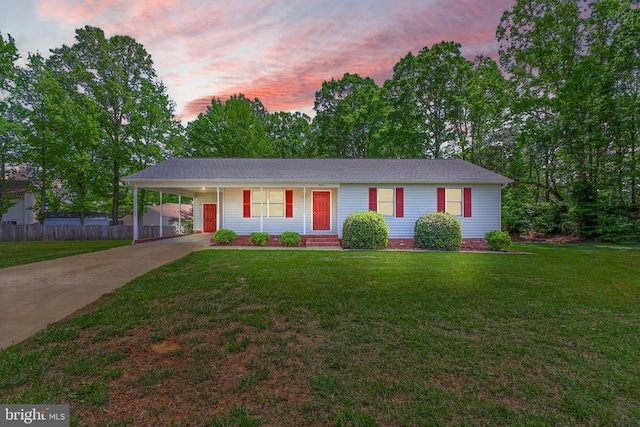 ranch-style house with concrete driveway and an attached carport