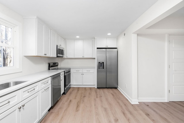 kitchen featuring light hardwood / wood-style flooring, white cabinets, and appliances with stainless steel finishes