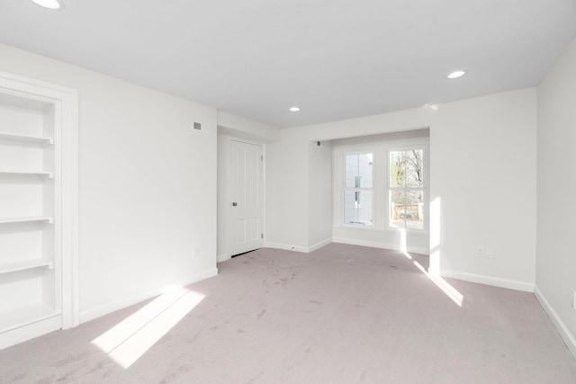 carpeted spare room featuring built in features