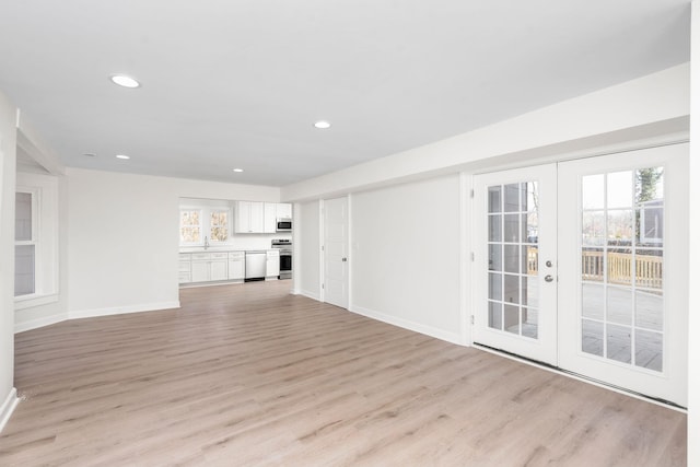 unfurnished living room featuring light hardwood / wood-style floors and french doors