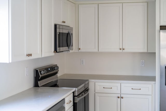 kitchen with appliances with stainless steel finishes and white cabinets