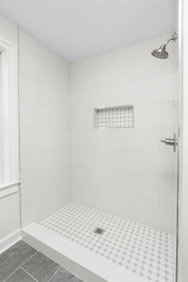 bathroom featuring tile patterned floors and a tile shower