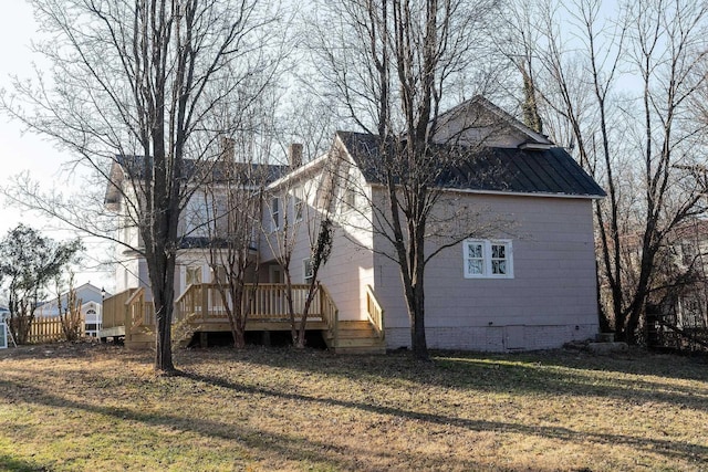 view of property exterior with a yard and a deck