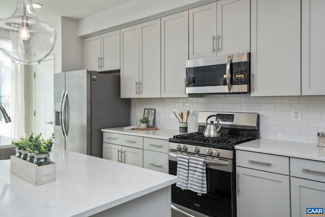 3215 Bergen St, Charlottesville, VA 22902 - kitchen with stainless steel appliances, backsplash, light stone counters, pendant lighting, and gray cabinetry