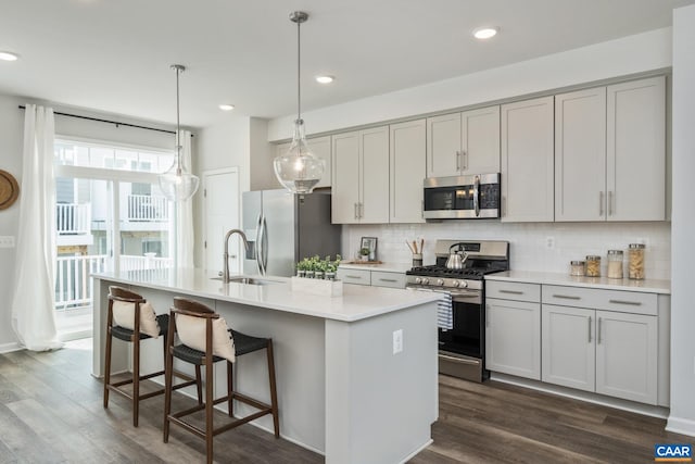 3215 Bergen St, Charlottesville, VA 22902 - kitchen featuring appliances with stainless steel finishes, a center island with sink, backsplash, dark wood-style floors, and recessed lighting