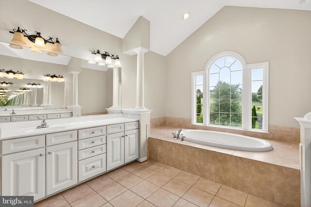 - bathroom featuring ornate columns, vanity, a garden tub, tile patterned floors, and high vaulted ceiling