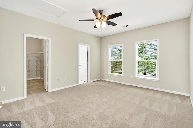  - unfurnished bedroom with attic access, carpet floors, and a ceiling fan