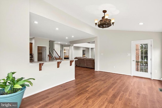  - unfurnished living room with wood finished floors, stairway, a chandelier, and recessed lighting