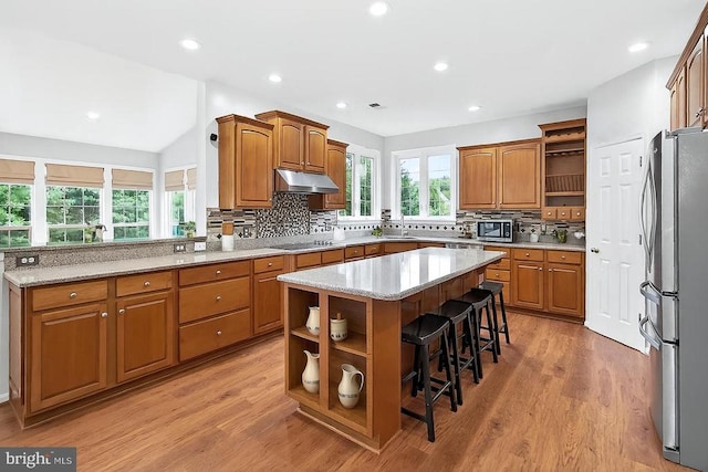  - kitchen with open shelves, stainless steel appliances, under cabinet range hood, decorative backsplash, and recessed lighting